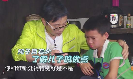极限男人帮陪伴留守儿童，王迅正给孩子播放他爸爸的录像。/《极限挑战》第四季