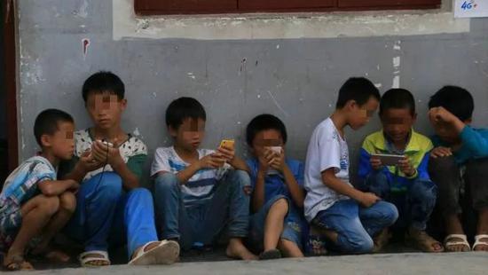 农村小孩在课后玩手机。