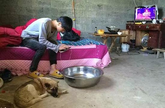 纪录片《小彪与狗》中，正在玩手机的贵州初二学生小彪。